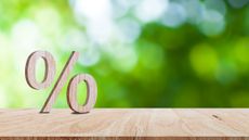 Close-up of percent sign leaning on a wooden table
