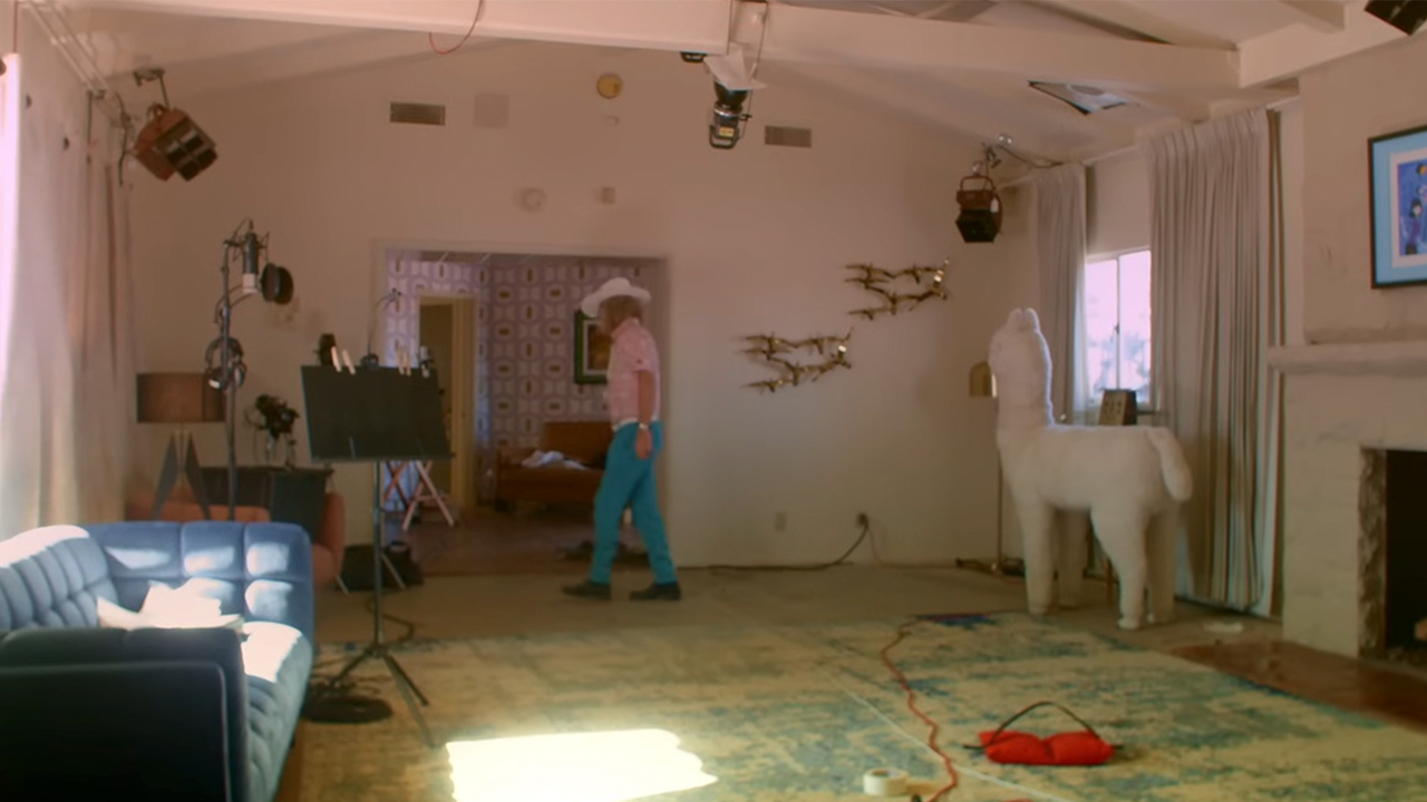 Ed Roland in a white cowboy hat and pink shirt, walking out of a room in Elvis Presley's house in Palm Springs