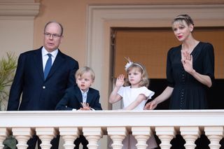 Princess Charlene and Prince Albert, alongside their twin children, Prince Jacques and Princess Gabriella of Monaco wave together from a balcony.
