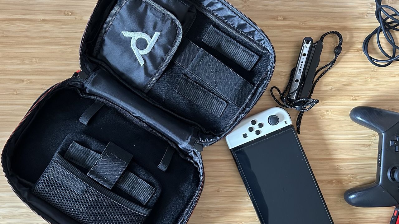 PDP commuter case open with Nintendo Switch next to it on a wooden table