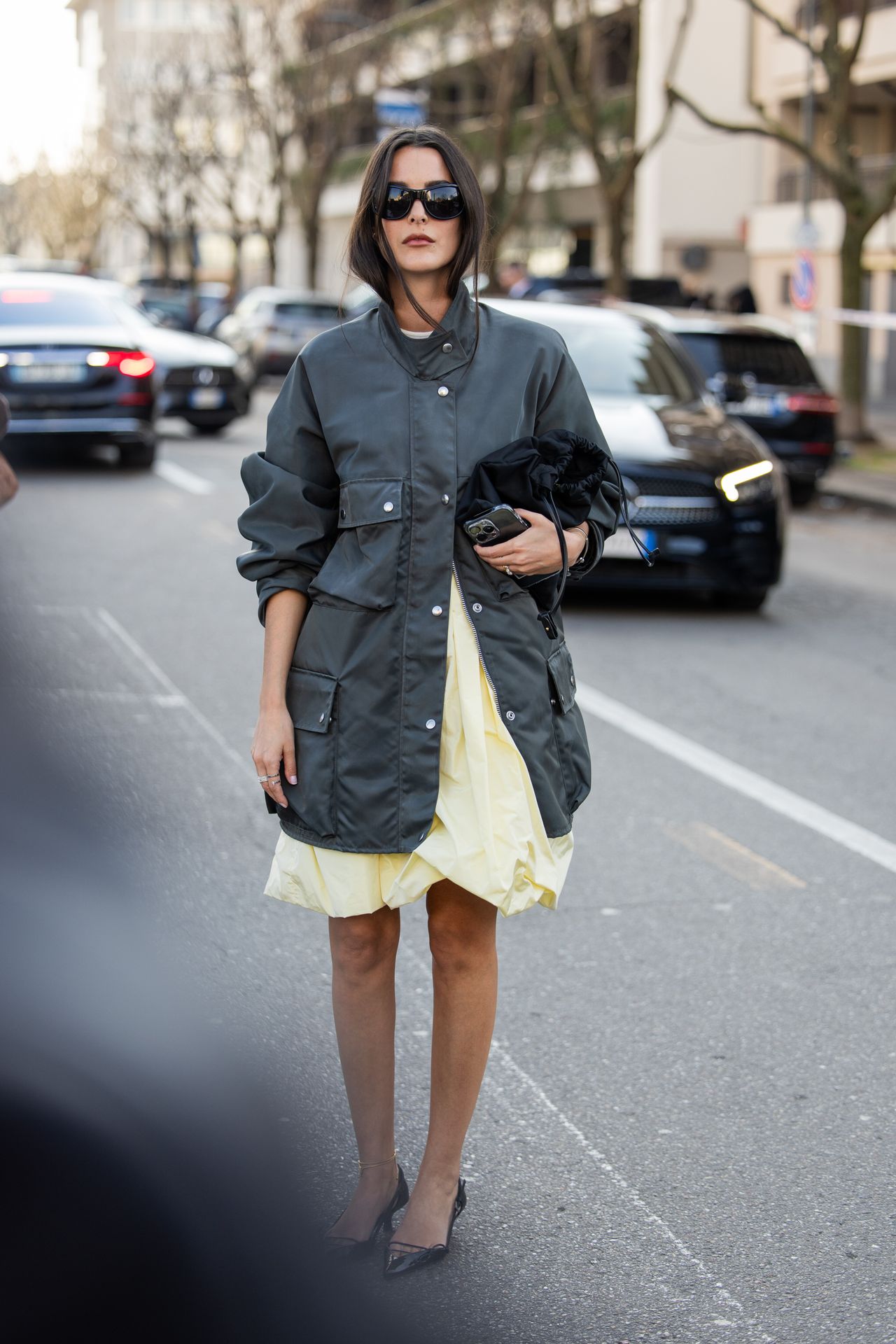 MILAN, ITALY - FEBRUARY 26: Leia Sfez wears grey jacket, yellow dress, black bag outside Prada during the Milan Fashion Week - Womenswear Fall/Winter 2026/2027 on February 26, 2026 in Milan, Italy. (Photo by Christian Vierig/Getty Images)