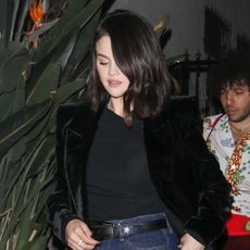 Selena Gomez wearing a velvet blazer, black top, and jean