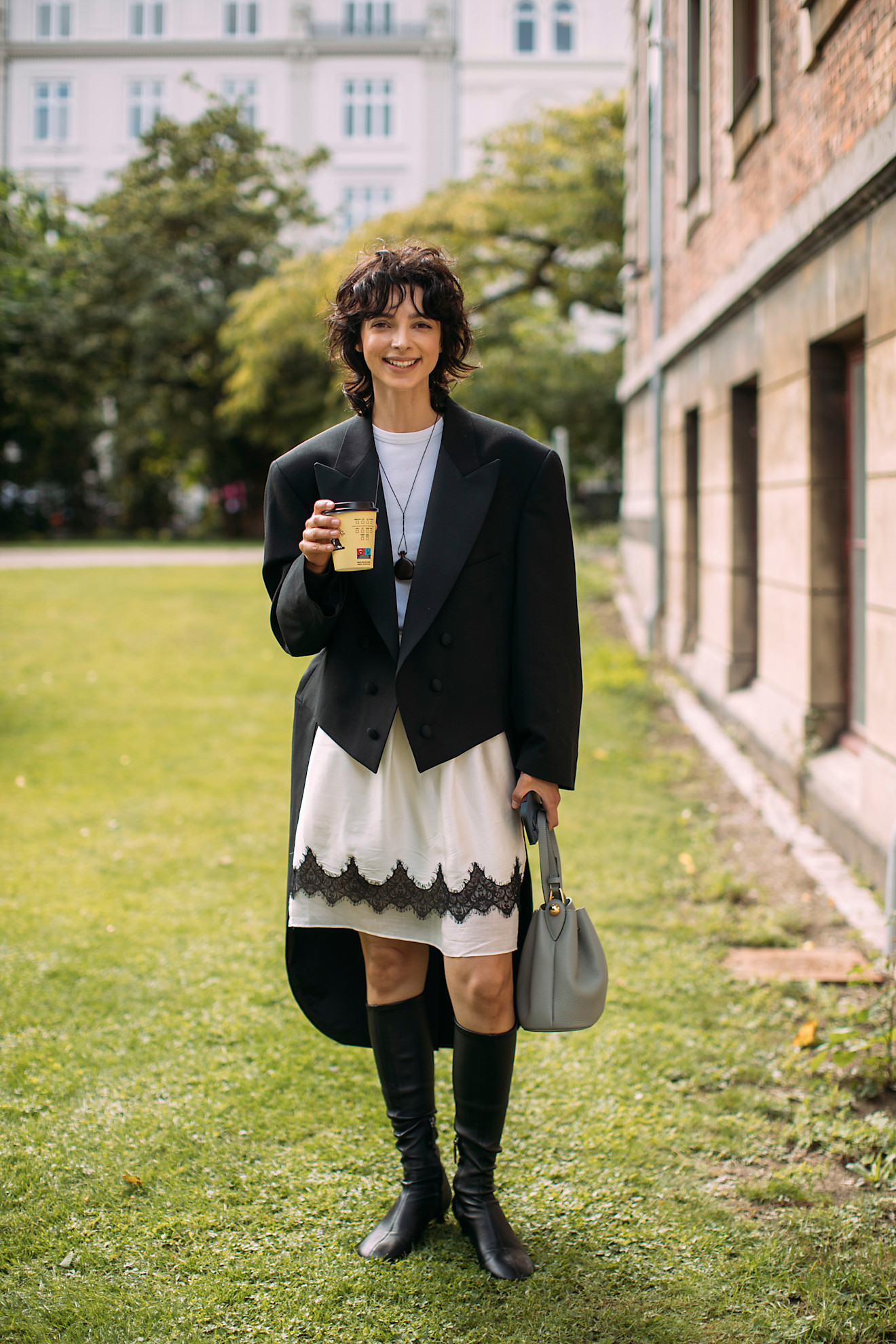 woman wearing a blazer and white lace-trimmed skirt