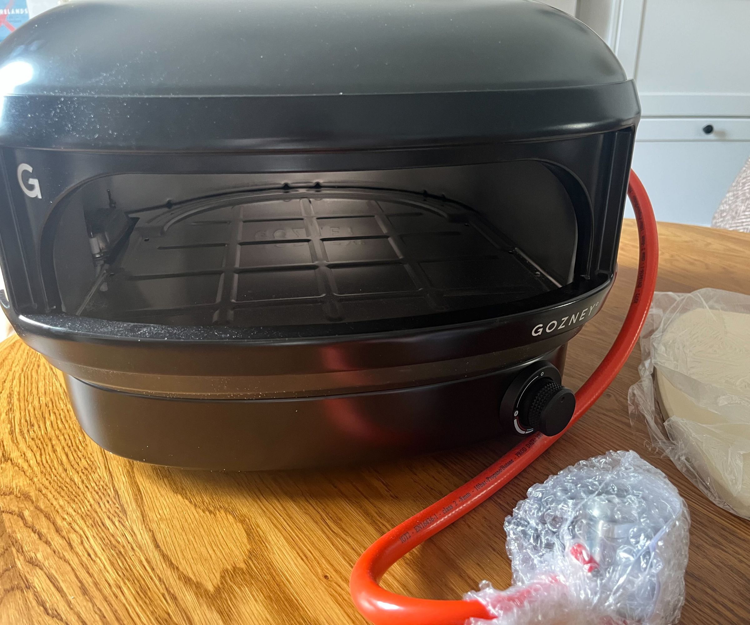 The black Gozney Arc Lite on a wooden coffee table. 