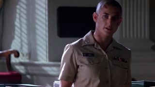 A bald Demi Moore looking tough in a navy uniform in G.I. Jane