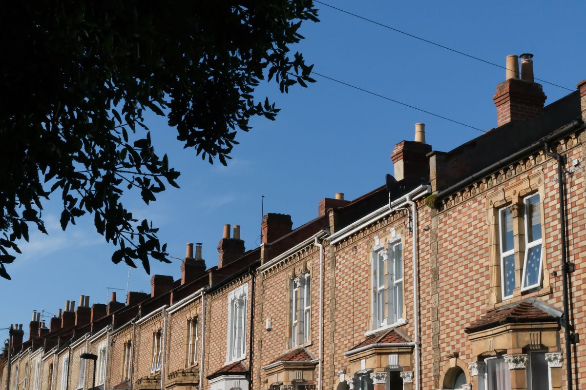 Red bricked houses stand under a blue sky, taken on a Fujifilm X-T50