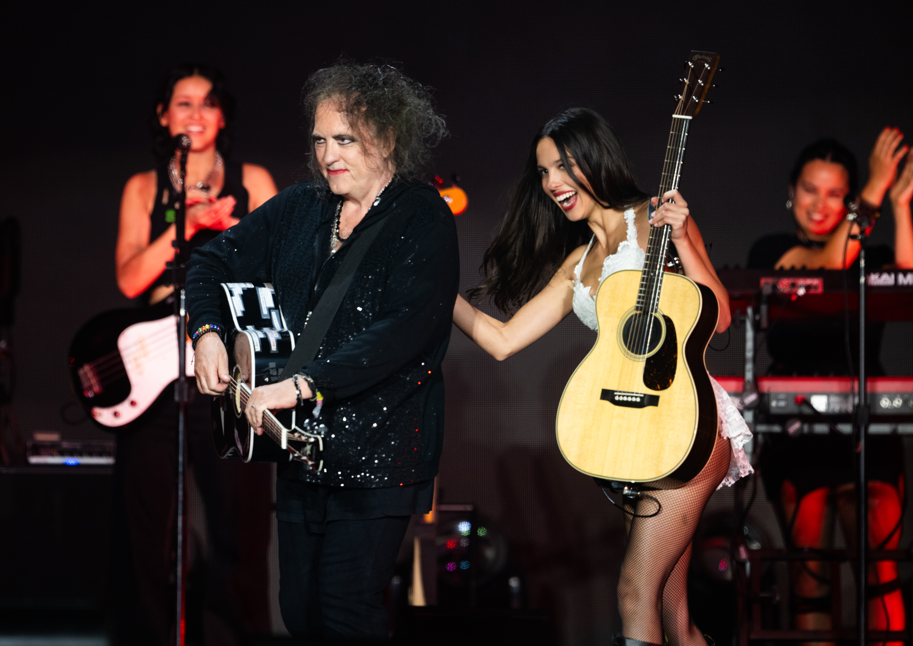 Robert Smith and Olivia Rodrigo smiling onstage at Glastonbury