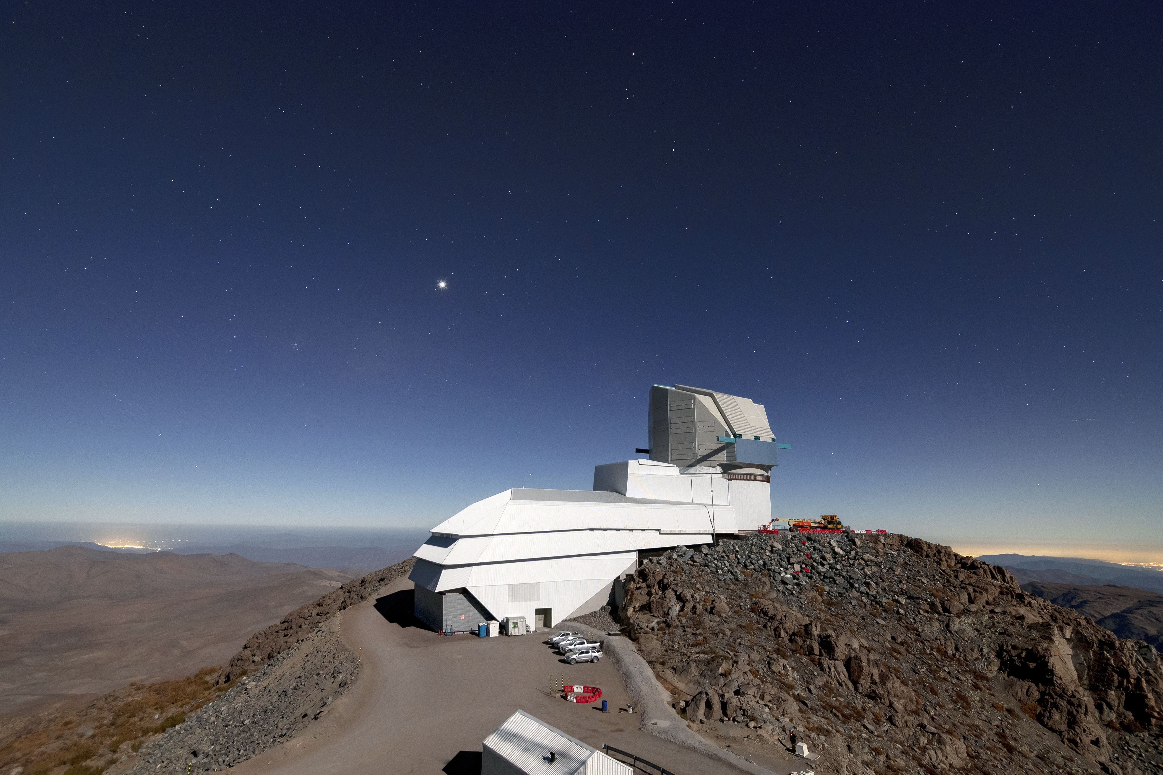 A white building sits on top of a rocky cliff