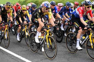 Wout van aert on stage 2 of the tour de france riding a one by bike in the middle of the peloton