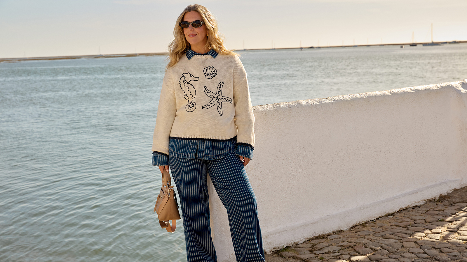 Erica Davies wearing a cream jumper and pinstripe denim outfit