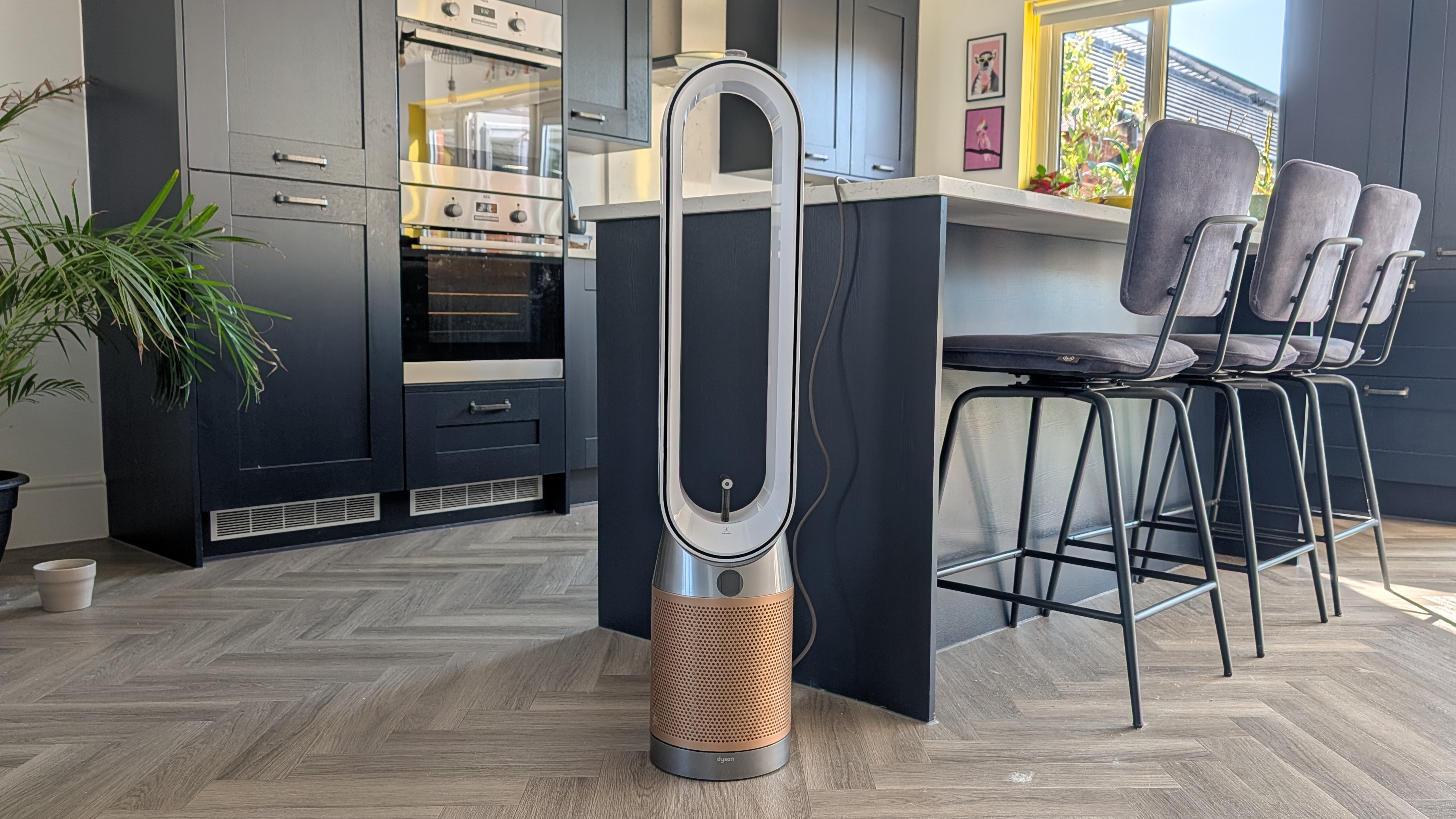 The Dyson Find+Follow Purifier Cool standing in someone's kitchen.