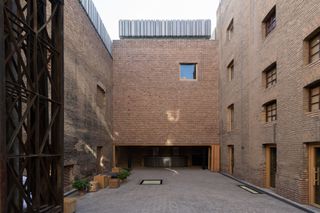 courtyard and entrance to the brick volumes of the agro factory art space in tehran