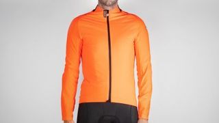 A male model in a bright orange cycling jacket with a black zip up the front