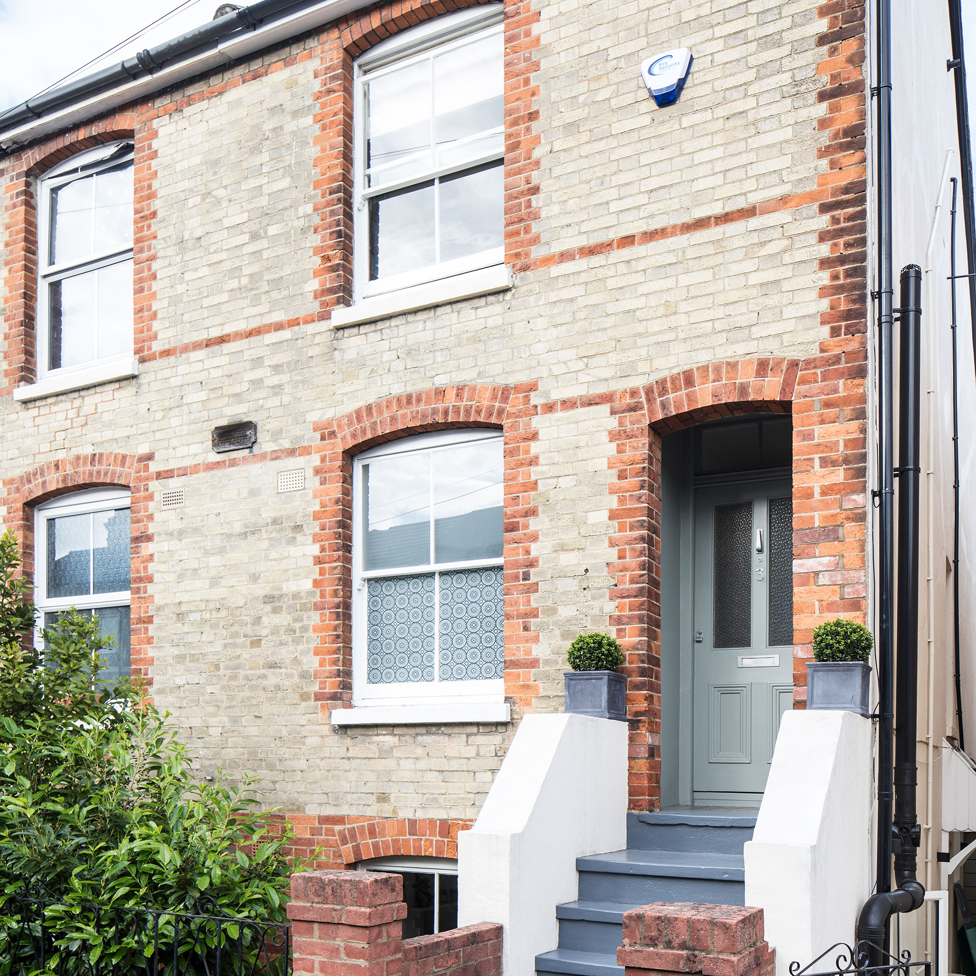 Edwardian semi-detached house with step entrance, arched windows and planters