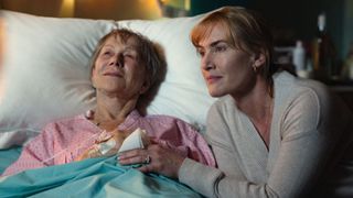 Helen Mirren lays in a hospital bed while Kate Winslet holds her hand