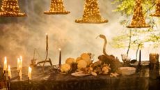 Smoky Anthropologie Halloween 2026 tablescape featuring dramatic candelabras, glowing witch hats, and skull-and-snake motif accents scattered throughout 
