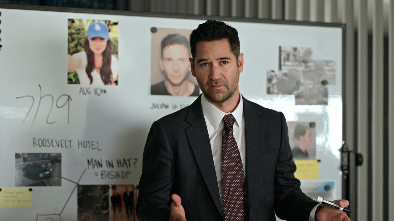 Manuel Garcia-Rulfo as Mickey Haller, standing in front of a whiteboard and window blinds, in episode 305 of The Lincoln Lawyer.