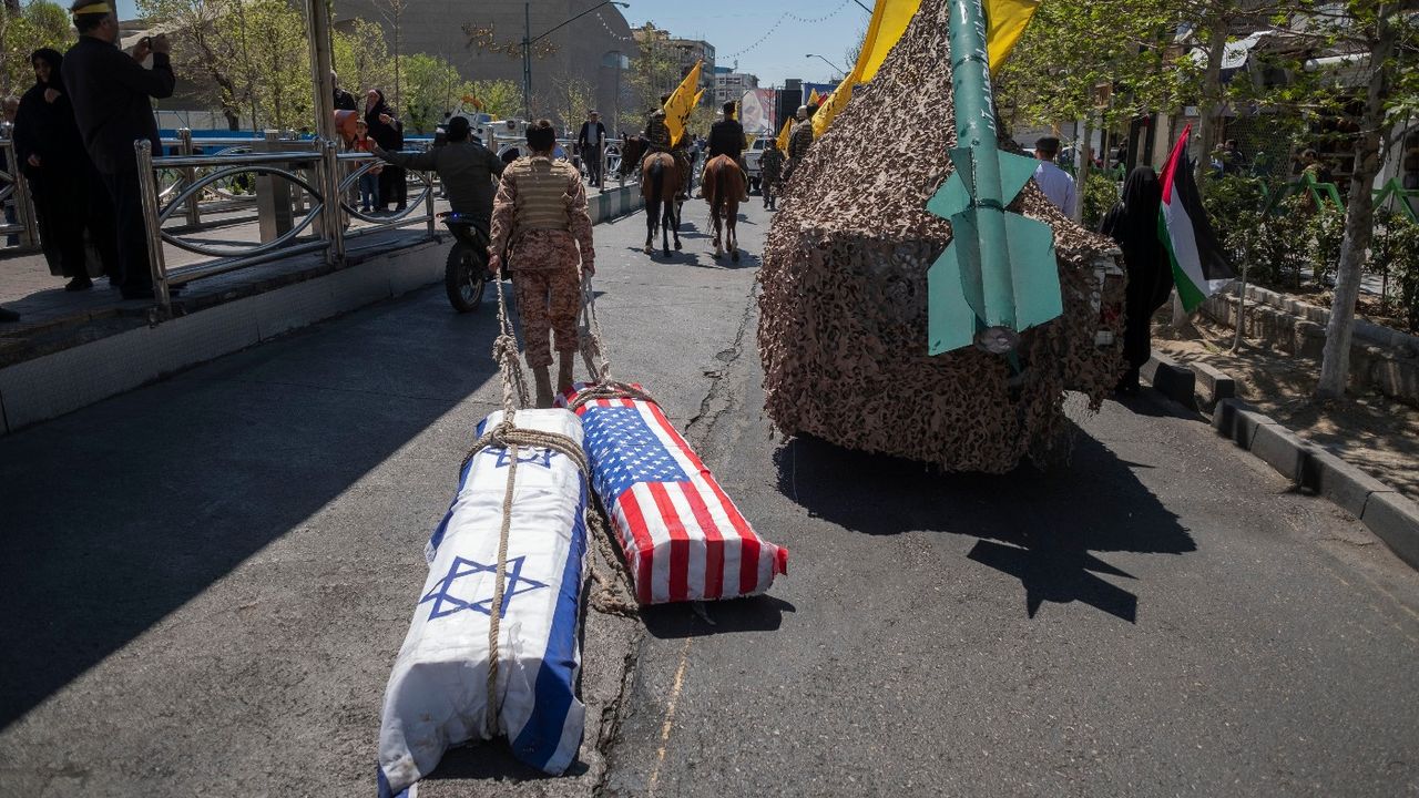 A member of the Islamic Revolutionary Guard Corps drags coffins symbolising the death of Israel and the US