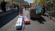 A member of the Islamic Revolutionary Guard Corps drags coffins symbolising the death of Israel and the US