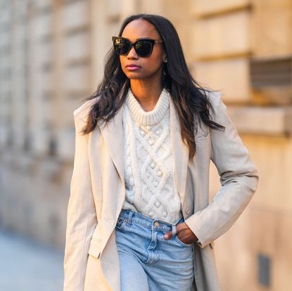 woman wears ivory cable knit sweater