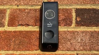 The fron view of the Eufy Video Doorbell Dual on a brick wall