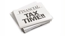 Stack of financial newspapers with the headline 'Tax Time!!'