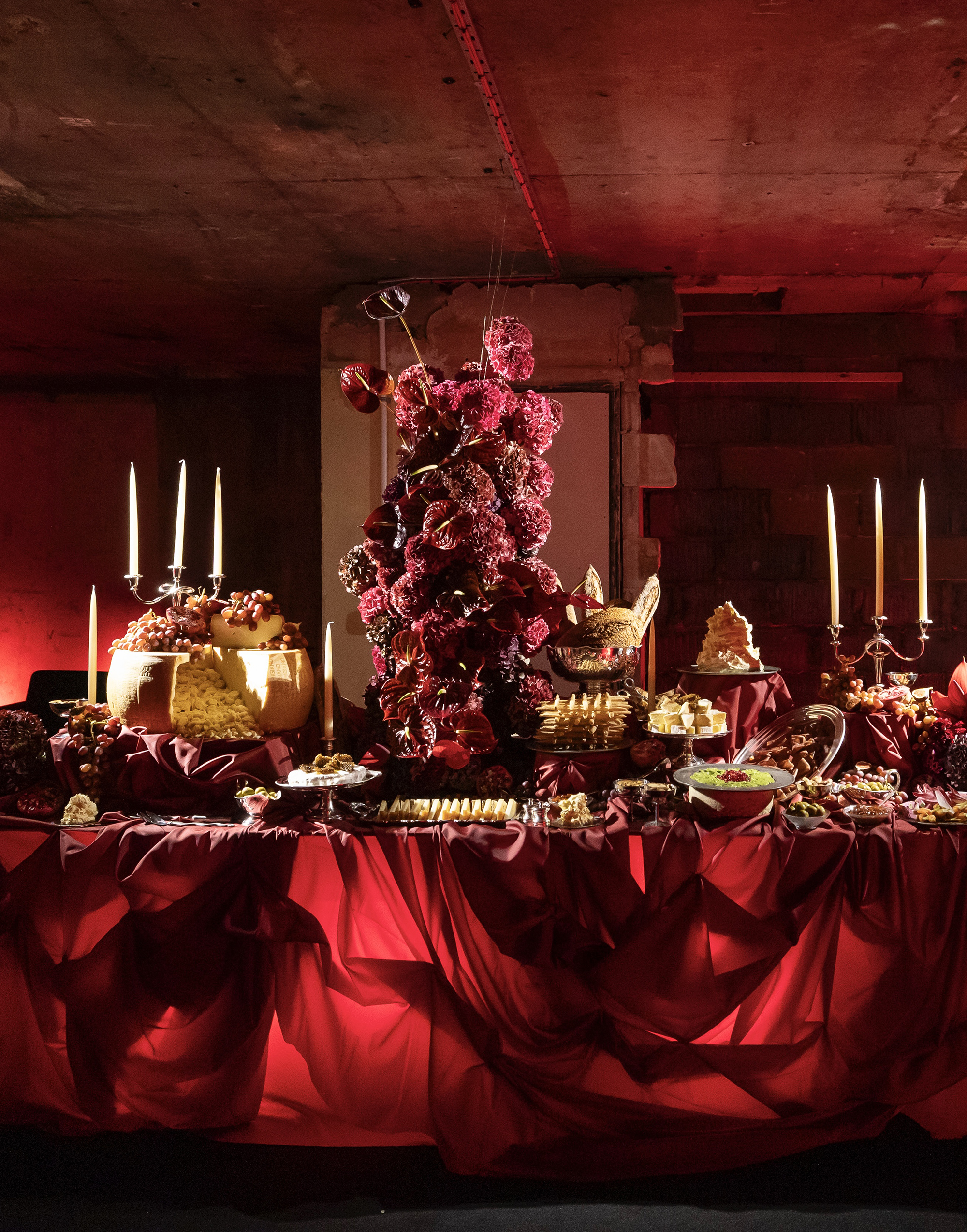 a gothic tablescape in red with large flowers in the center