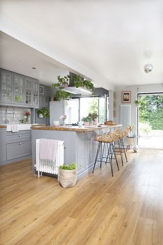 Grey Shaker-style kitchen and island with rattan bar stools