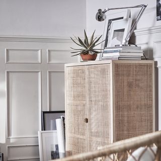 light wood cabinet plant and lamp over it