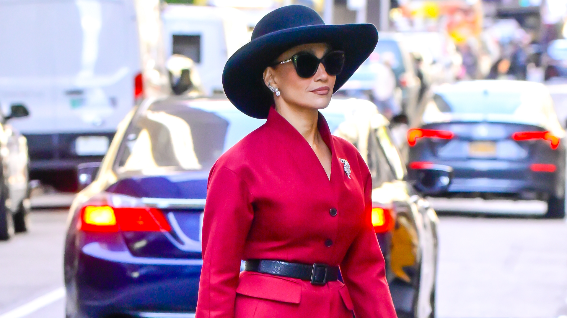 Jennifer Lopez was spotted on the set of her new movie wearing a burgundy skirt set, a croc-embossed bag, a hat, and checkered Mary Janes