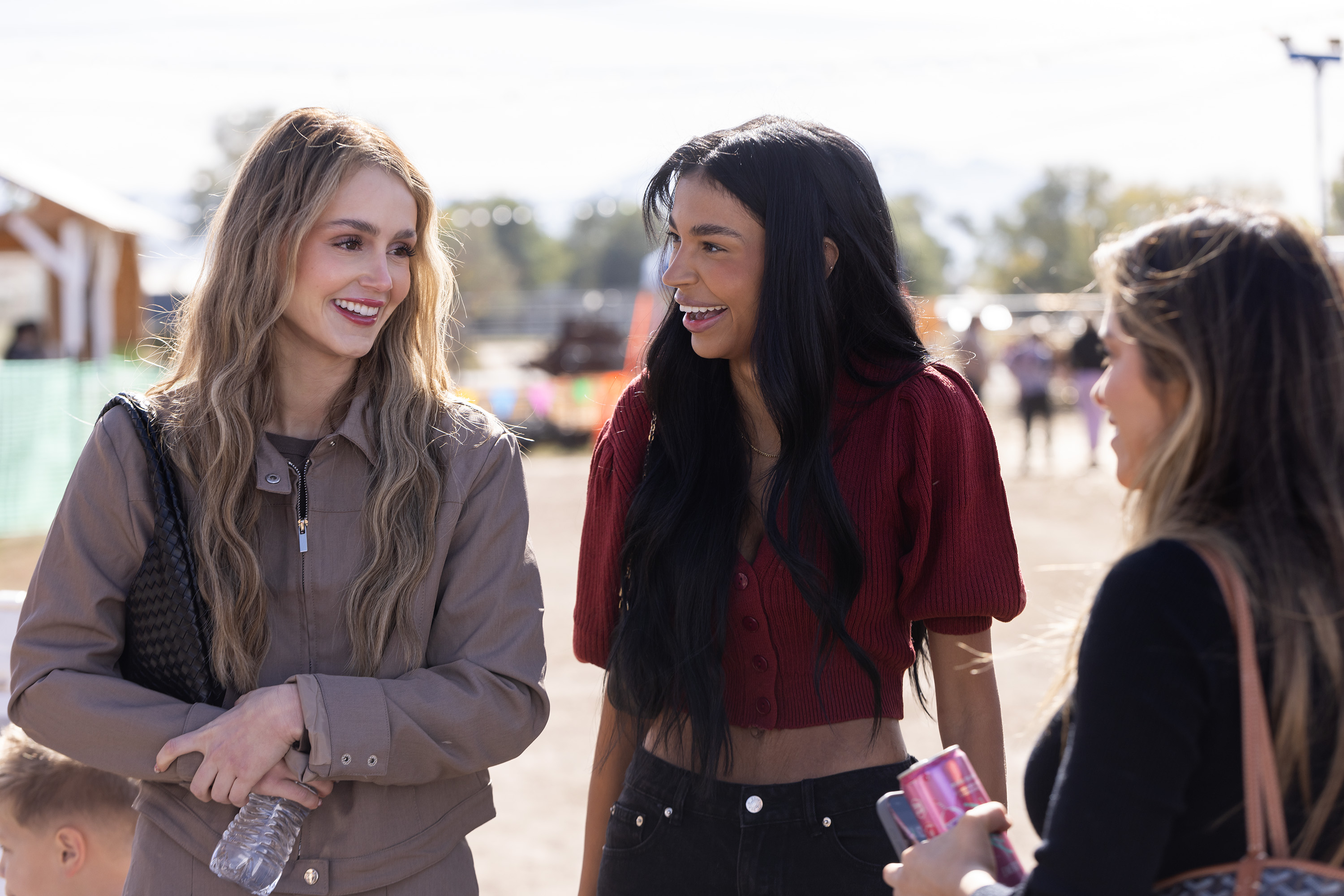 Mikayla Matthews, Layla Taylor, and Taylor Frankie Paul, standing outdoors at a fair, in 'The Secret Lives of Mormon Wives' season 2.
