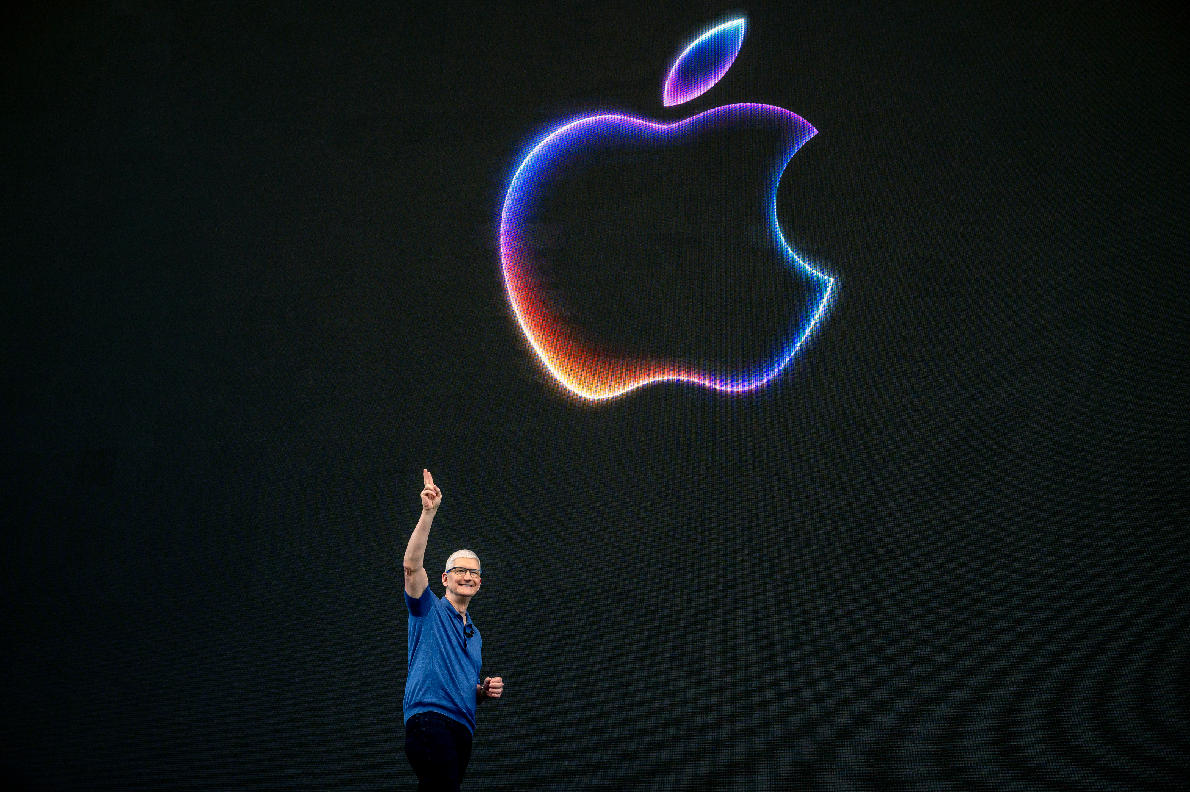Tim Cook on stage presenting at WWDC 2024 in front of an Apple logo