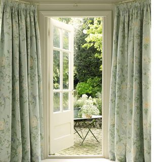 floral curtains with white door and garden area