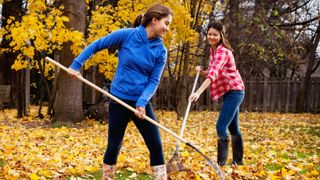girls raking up leaves