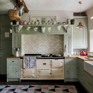 kitchen with cabinets and rug on floor with metro tiles and aga