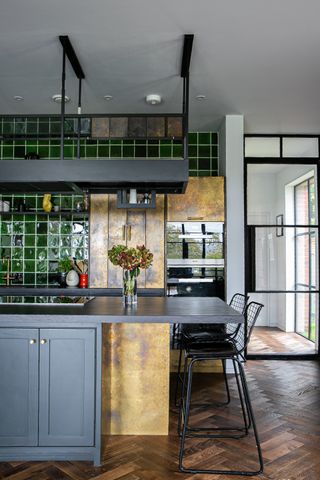 Green and gold kitchen with black kitchen island idea