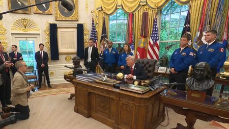 President Donald Trump welcomed the four Artemis 2 astronauts (in blue flight suits) and NASA Administrator Jared Isaacman (in dark suit, in front of American flag) to the Oval Office on April 29, 2026.