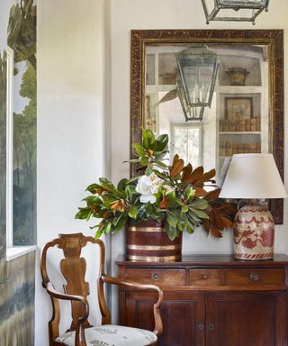 Detail of a dining room with antique lanterns and mahogany sideboard