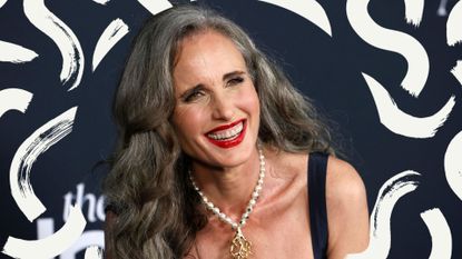 Actor Andie Macdowell, pictured in a black dress with red lipstick after transitioning to gray hair 