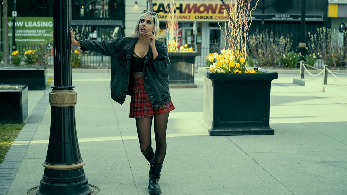 Lila Pitts stands on a street corner while speaking on the phone in The Umbrella Academy season 3