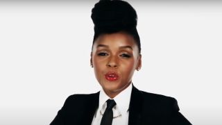 Janelle Monae dressed in a suit talks to the camera.