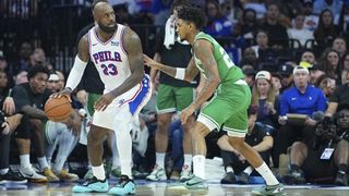 LeBron James #23 of the Philadelphia 76ers dribbles the ball against Dillon Mitchell #20 of the Boston Celtics during an NBA 2026/27 preseason game.