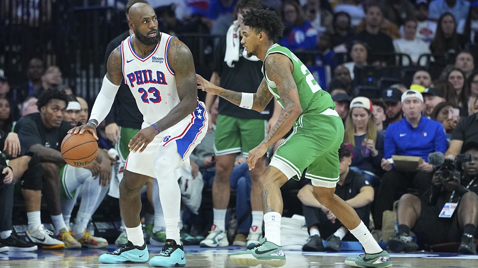 LeBron James #23 of the Philadelphia 76ers dribbles the ball against Dillon Mitchell #20 of the Boston Celtics during an NBA 2026/27 preseason game.