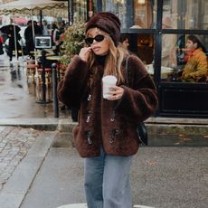 @slipintostyle wearing a faux fur hat, a French girl winter wardrobe staple.