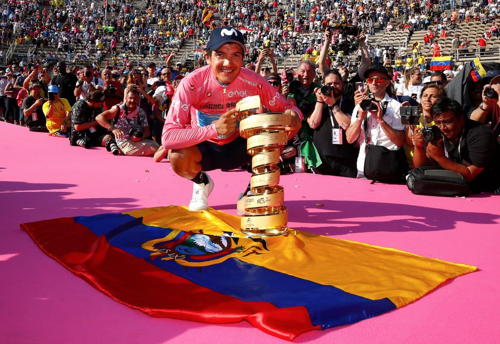 2019 Giro d'Italia winner Richard Carapaz poses with Ecuador's flag on the final podium in Verona.