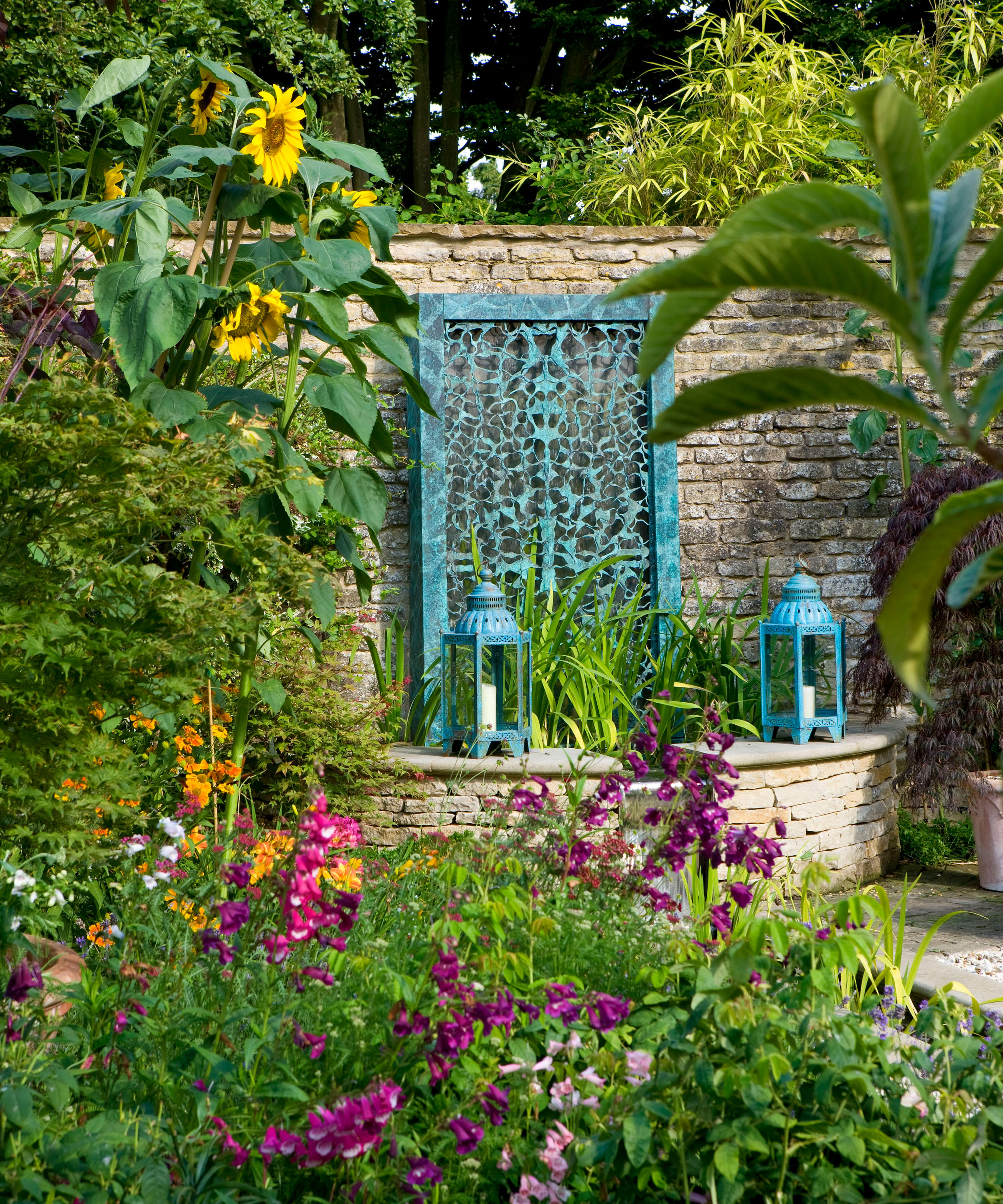 filigree bronze water wall by David Harber in a country garden