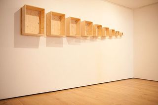 Wooden boxes displayed on left white walls in a room