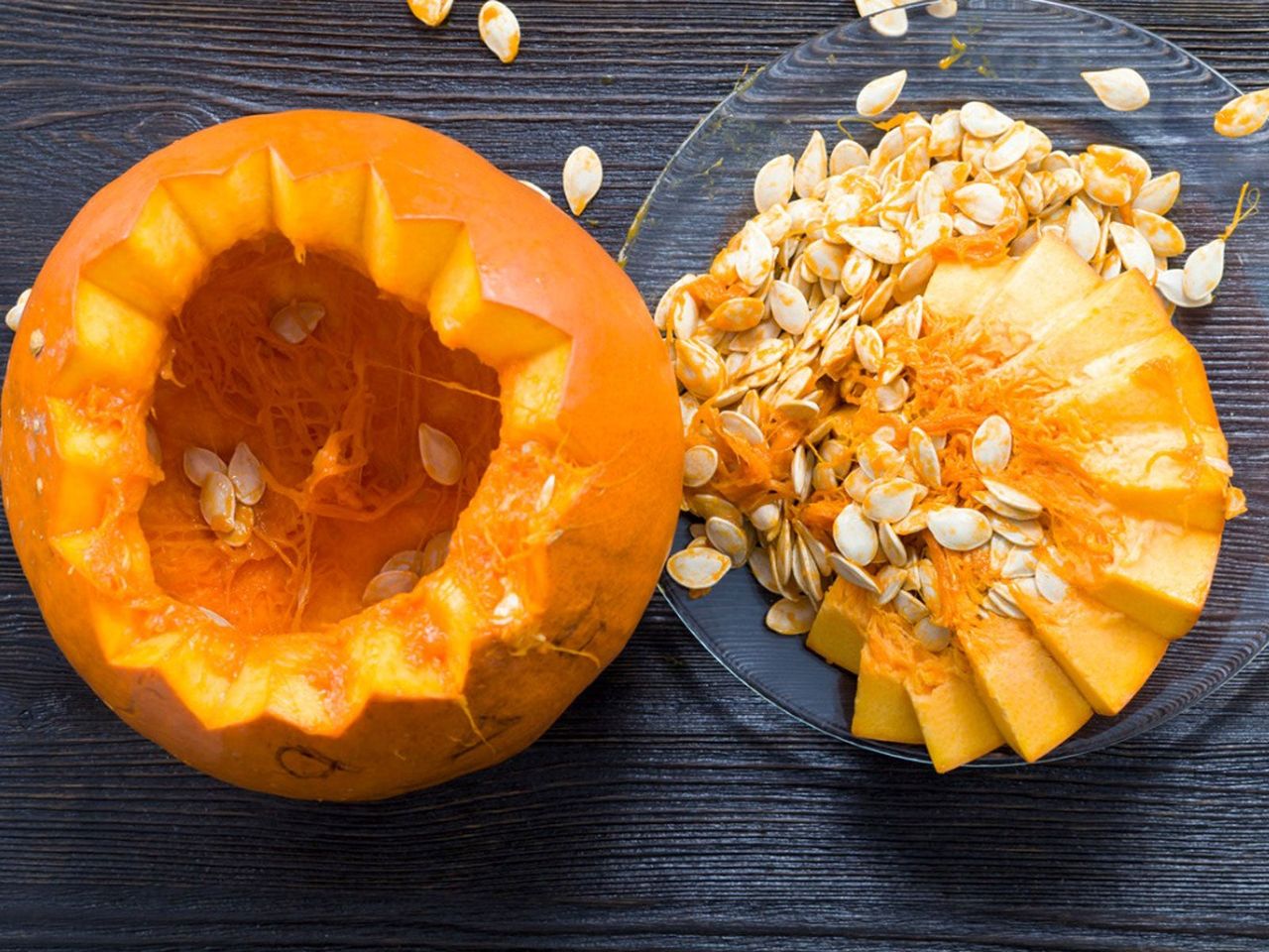 Top Cut Off Of Pumpkin On A Plate Full Of Seeds