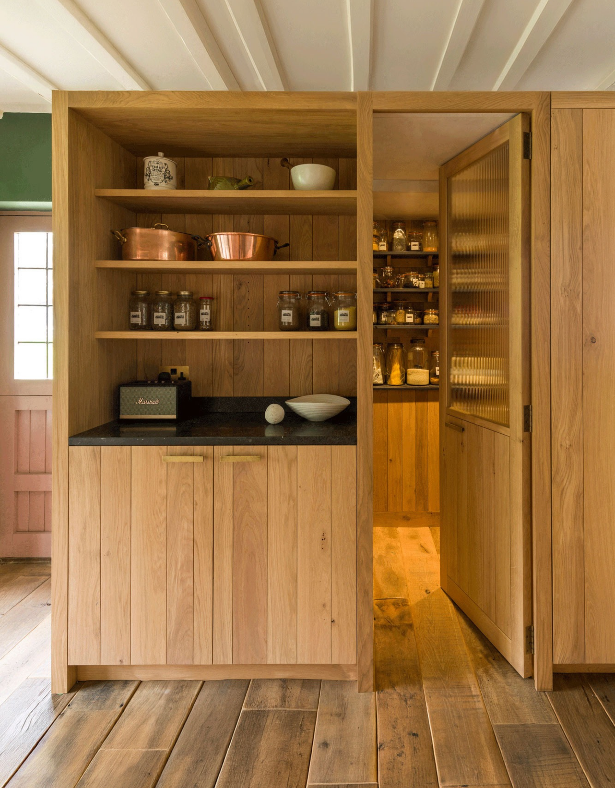 wooden kitchen with open shelving and a concealed pantry room built behind the cabinetry