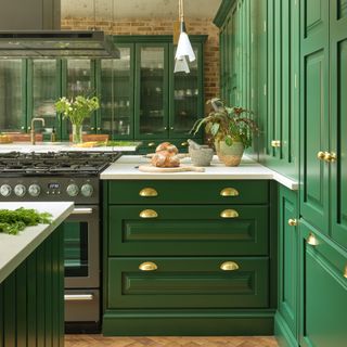 green kitchen with antique mirror splash back and brass knobs
